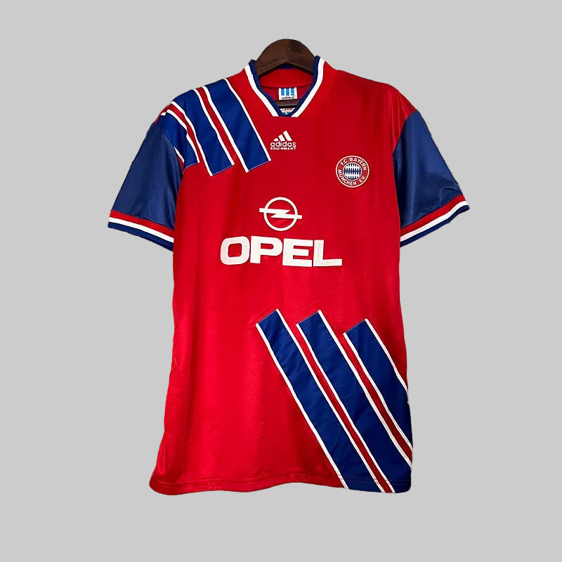 Bayern Munich football shirt with red, blue, and white colors, adidas logo, and the name 'OPEL' on the front.