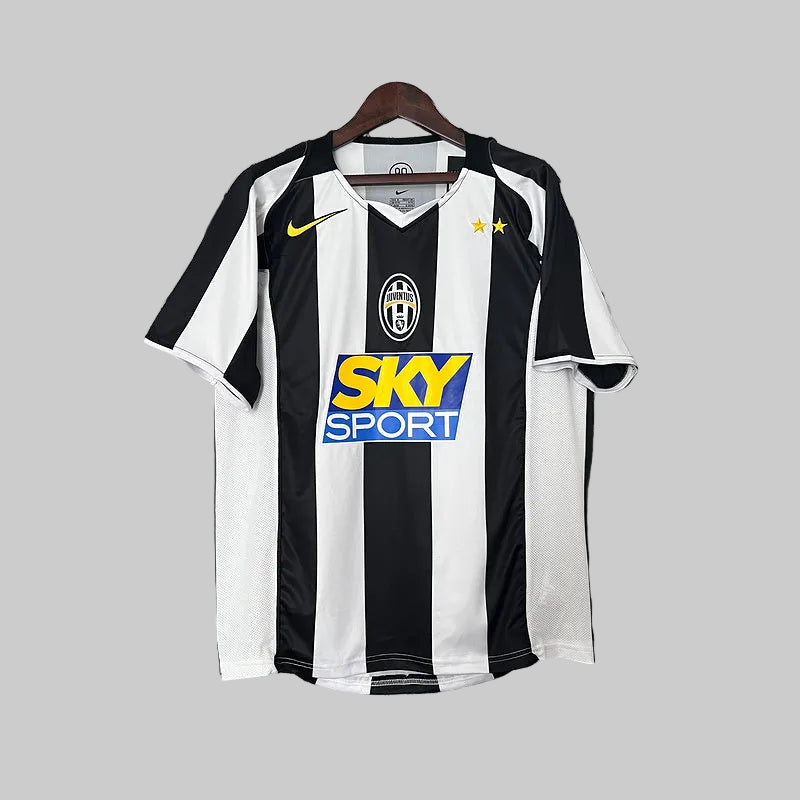 A Juventus soccer jersey from the 2004/05 season, predominantly black with white and yellow details, hanging on display.